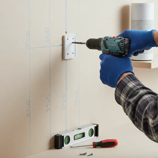 A person installing a smart speaker wall mount onto a wall, highlighting the importance of proper tools and considering wall type for secure installation.